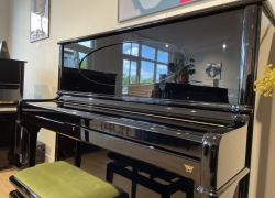 Seiler piano, model Concert 132cm in zwart hoogglans met ovaal in het bovenraam en Renner mechaniek met SMR-systeem (Super Magnet Repetition) waarmee een vleugelrepetitie behaald kan worden. (ook onderin de toets) Bouwjaar 2005