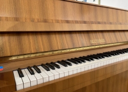 Exclusieve piano van het top merk Blüthner uit Leipzig (D). 112cm hoog, in noten gesatineerd, bouwjaar 1974.