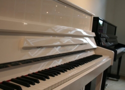 Gustav Kern piano, model 120cm Concert, in zwart polyester hoogglans, afgewerkt met chroom beslag.